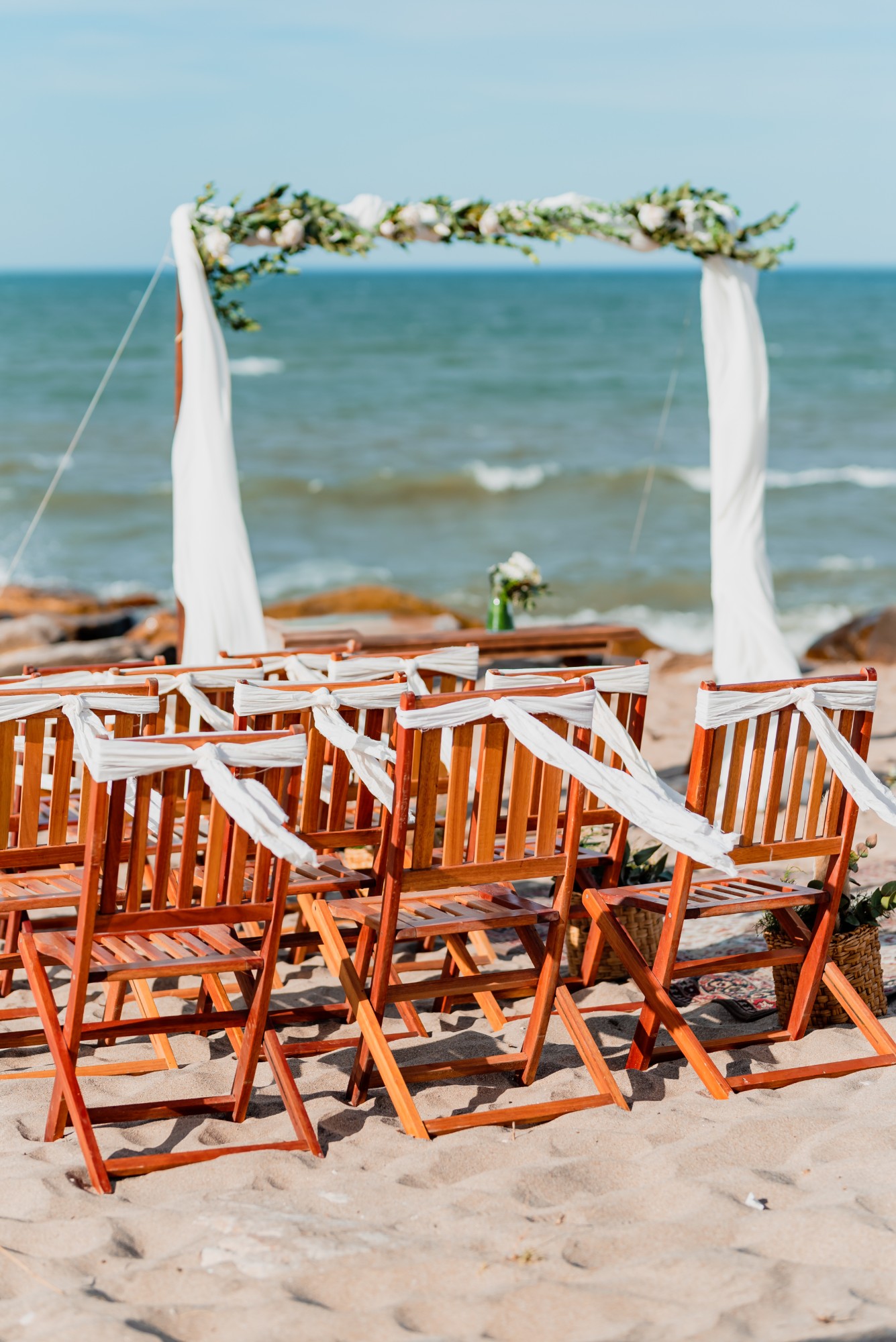 Sillas con moños blancos y arco en la playa — Mar Eventos