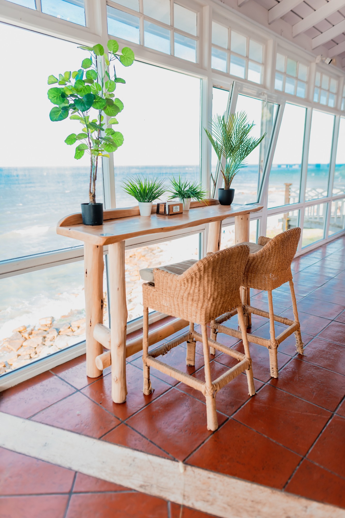 Mesa alta con banquetas de ratán frente al mar — Mar Eventos