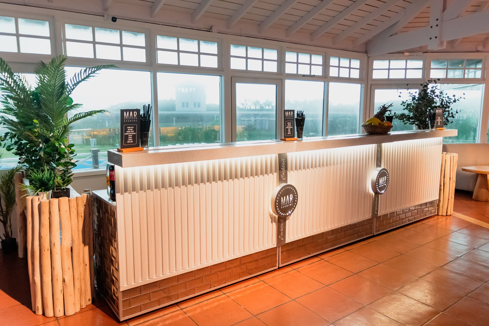 Barra blanca del salón con plantas — Mar Eventos